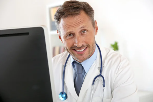 Läkare som sitter framför datorn — Stockfoto