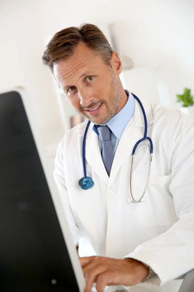 Médico sentado na frente do computador — Fotografia de Stock