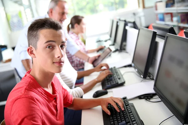 Boy sitting in front of desktop computer — Stock Photo, Image