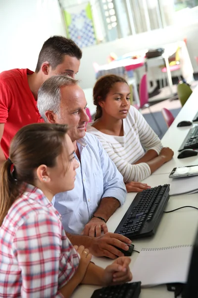 Tieners met leraar in computers klasse — Stockfoto