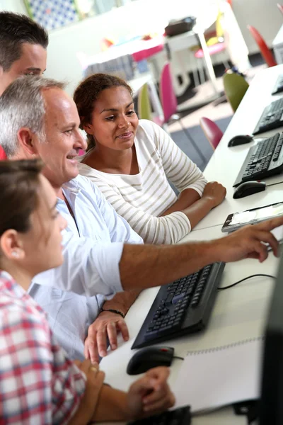 Tieners met leraar in computers klasse — Stockfoto