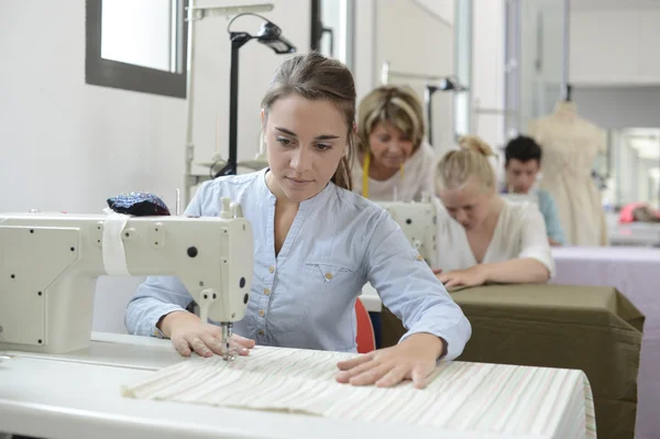Estudiante en clase de formación trabajando en la máquina de coser — Foto de Stock