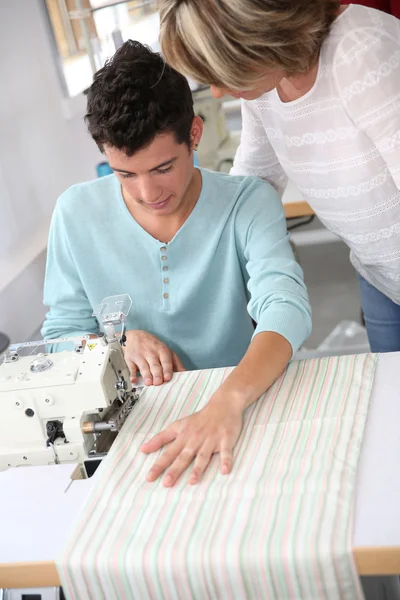 Kvinna i klädsömnad klass hjälpa student — Stockfoto