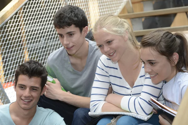 Students sitting in schoolyard — Stock Photo, Image