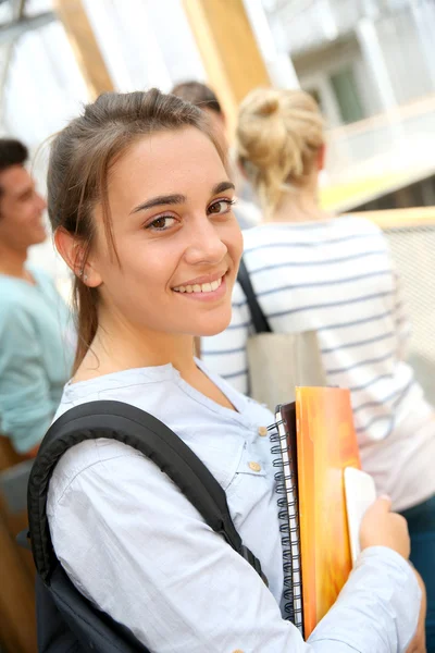 Szilikát tégla tégla fal学校でノートを保持している 10 代の少女 — ストック写真