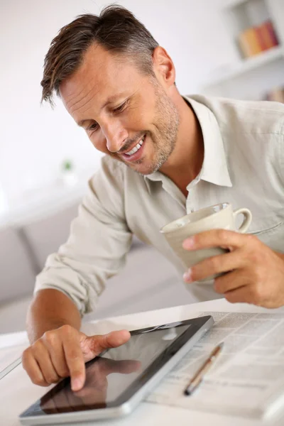 Hombre leyendo noticias en la tableta y beber café Fotos de stock libres de derechos
