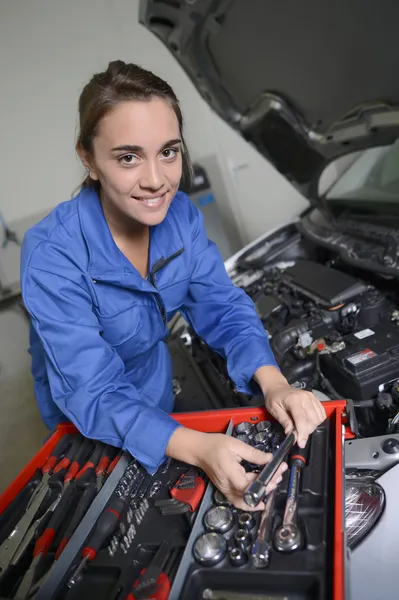 Студентка-механик, работающая над автомобильным двигателем — стоковое фото