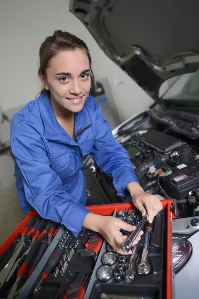 Studente ragazza in meccanica che lavora sul motore auto — Foto Stock