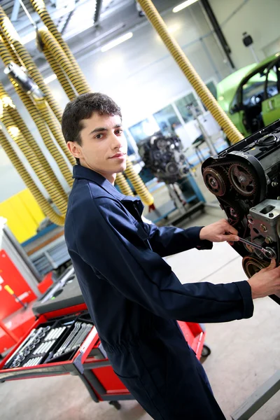 Student v mechanice pracuje na motor — Stock fotografie