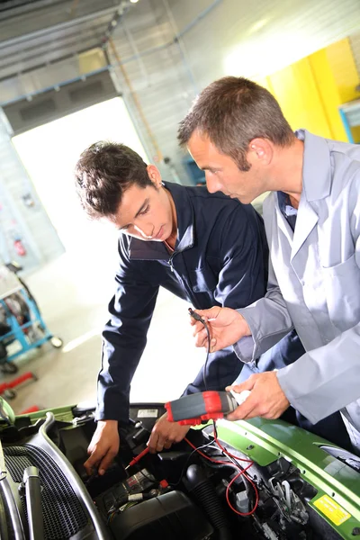 Trainer met student in repairshop — Stockfoto