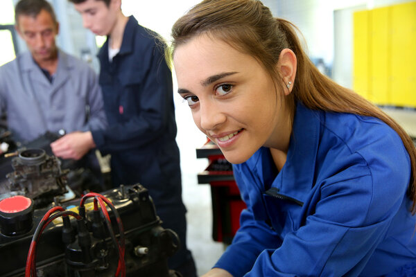 Student girl working in auto repairshop
