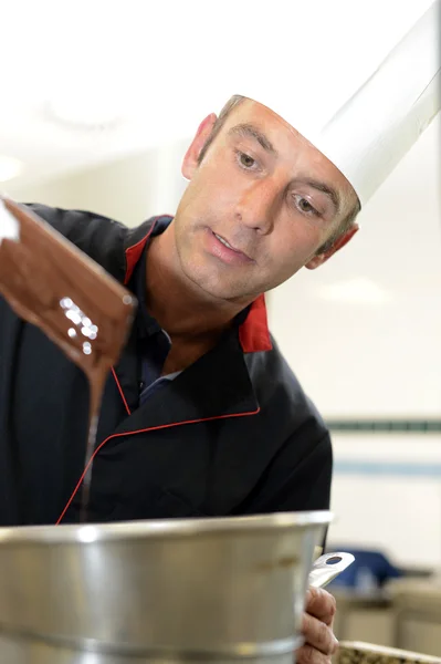 Chef pâtissier regardant mélange gâteau au chocolat — Photo