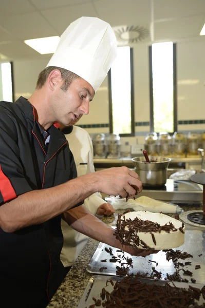 Teacher making chocolate cake — Stock Photo, Image