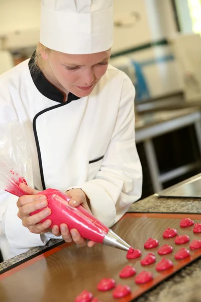 Cozinheiro estudante de pastelaria fazendo biscoitos vermelhos — Fotografia de Stock