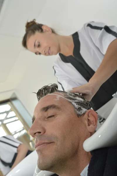 Женщины моют волосы клиенту — стоковое фото