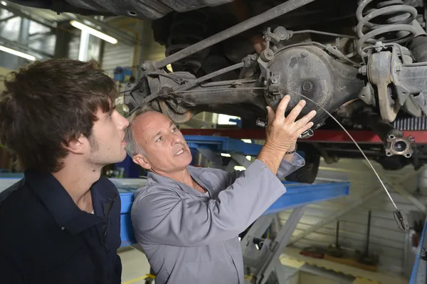 Profesor con estudiante en taller de reparación de automóviles — Foto de Stock