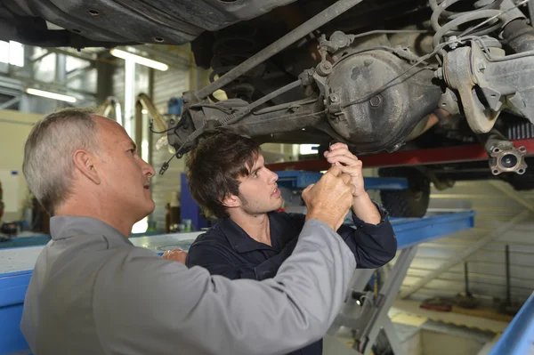 Professeur avec étudiant en atelier de réparation automobile — Photo
