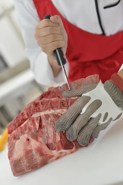Ribs being cut in butcher kitchen — Stock Photo, Image