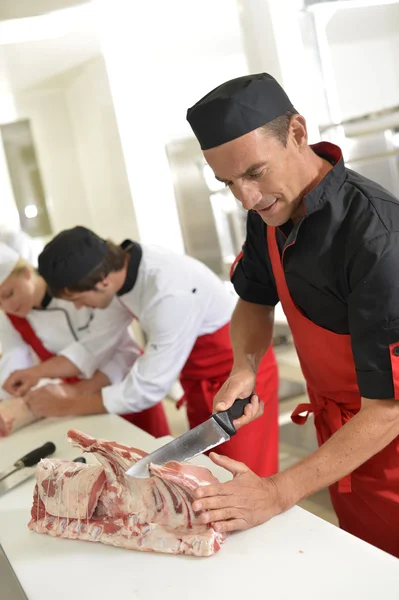 Açougueiro que prepara costelas de carne — Fotografia de Stock