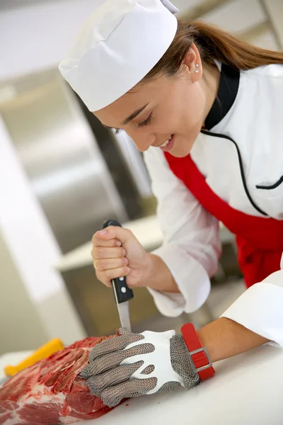 Butcher girl cutting ribs — Stock Photo, Image