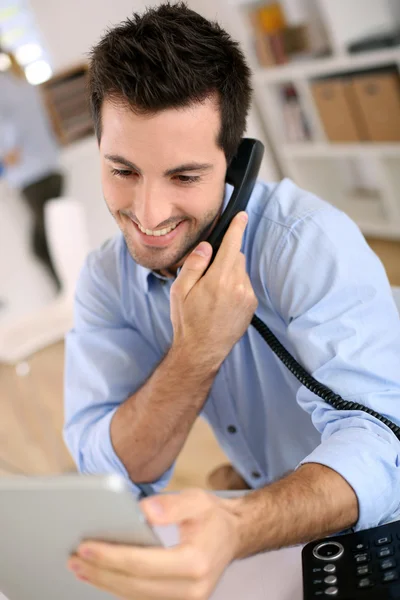 Homem no escritório atender o telefone — Fotografia de Stock