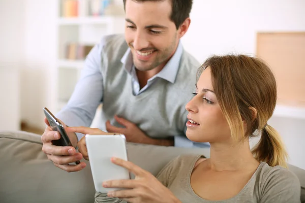 Paar nutzt Smartphone zu Hause — Stockfoto
