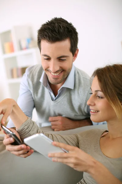 Couple utilisant un smartphone à la maison — Photo