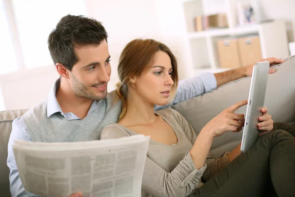 Пара читає новини як на пресі, так і в Інтернеті — стокове фото
