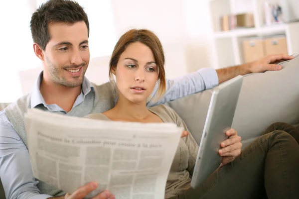 Pareja leyendo noticias tanto en prensa como en internet —  Fotos de Stock