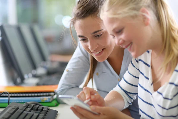 Girls using smartphone in class Royalty Free Stock Photos