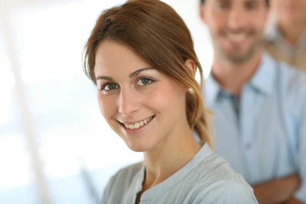 Girl standing in front of business team Stock Image