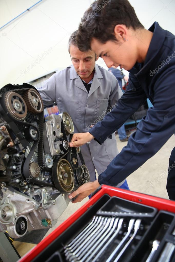 Teacher and student in auto mechanics training class