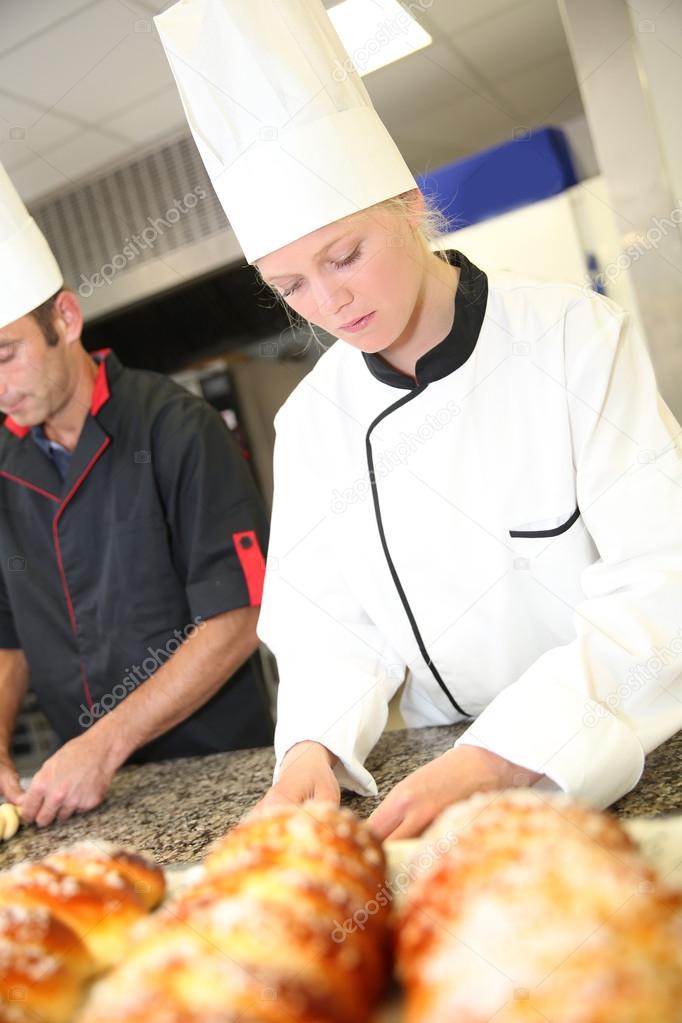 Baker with students in kitchen