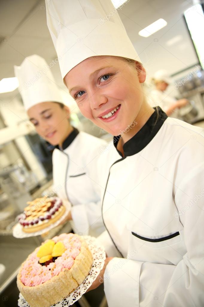 Students girls in pastry holding cakes