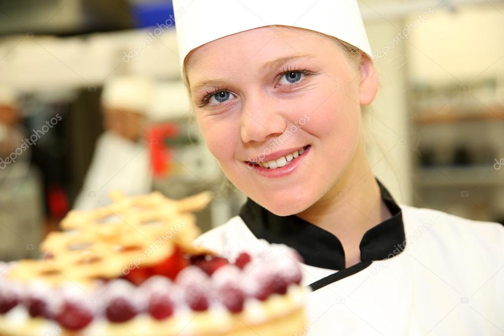 Young confectioner holding cake