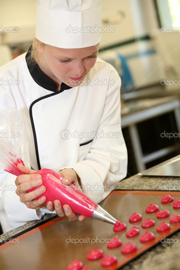 Pastry cook student making red cookies