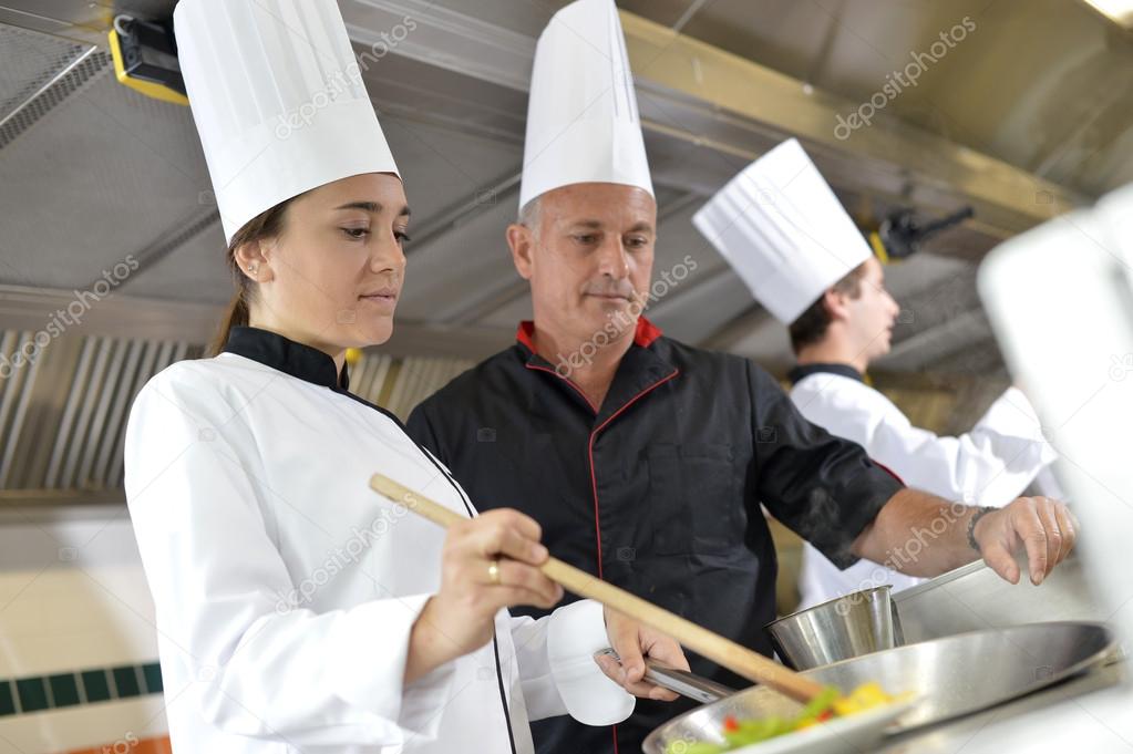 Chef teaching student how to prepare wok dish