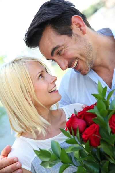 Homem dando rosas vermelhas à mulher — Fotografia de Stock