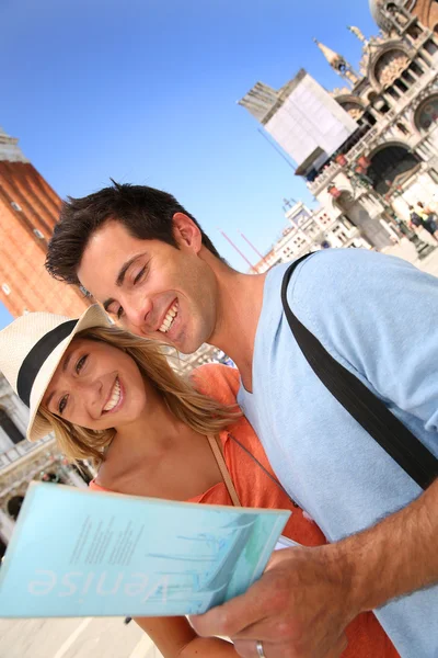 Couple reading tourist guide on San Marco place — Stock Photo, Image