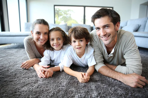 Familjen avkopplande på mattan — Stockfoto