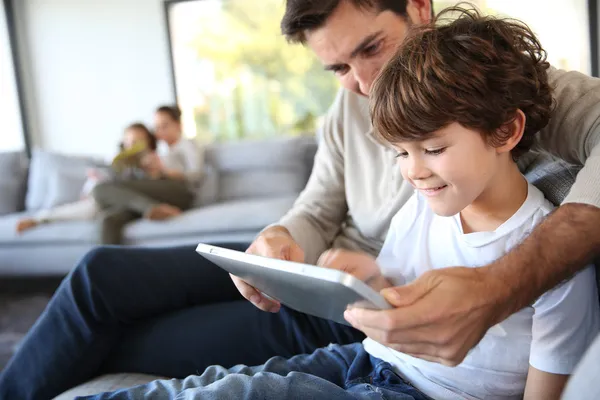 Отец и сын играют с цифровым планшетом — стоковое фото