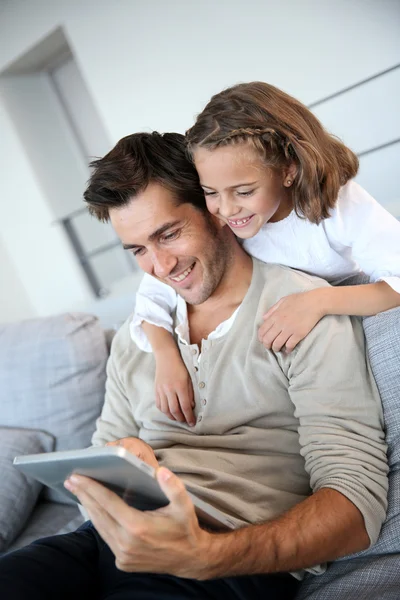 Мужчина с дочерью играют с цифровым планшетом — стоковое фото