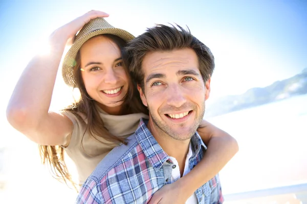 Man die geeft piggyback rit te vriendin — Stockfoto