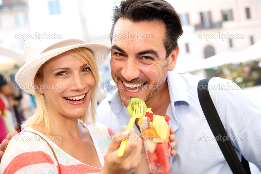 Tourists having fun eating fresh fruits
