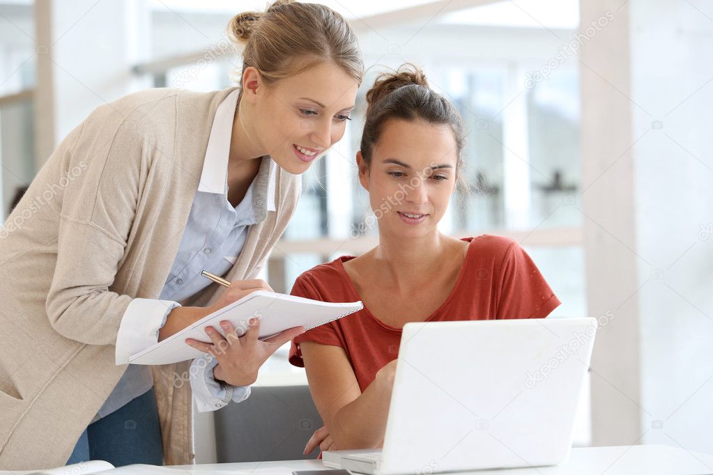 Businesswomen working together on laptop