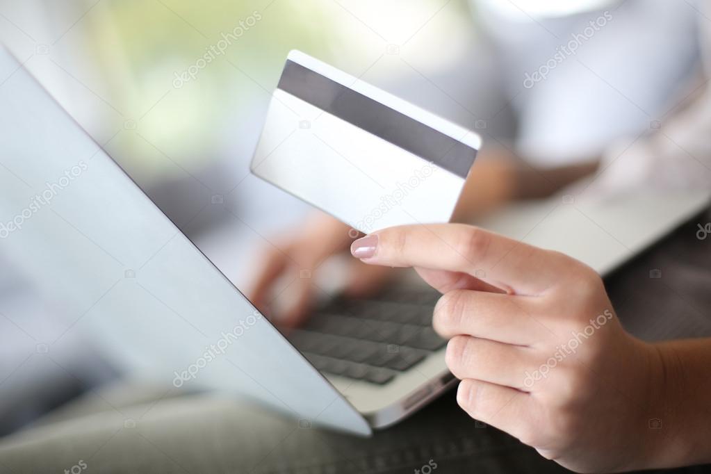 Hand holding credit card to buy online