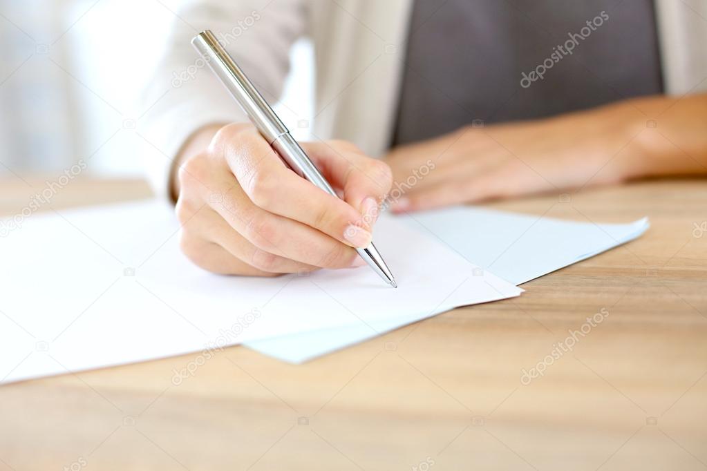 Woman's hand writing on paper