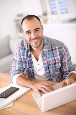 Dizüstü bilgisayarda çalışan adam
