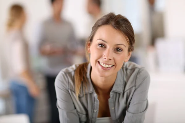 Business girl sitting on table in office — Stock Photo, Image