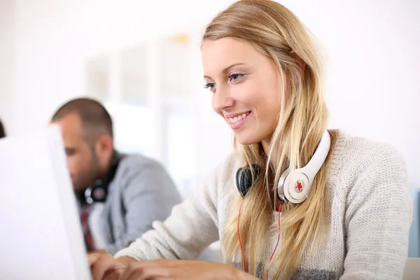 Chica sentada en clase y trabajando en el ordenador portátil —  Fotos de Stock